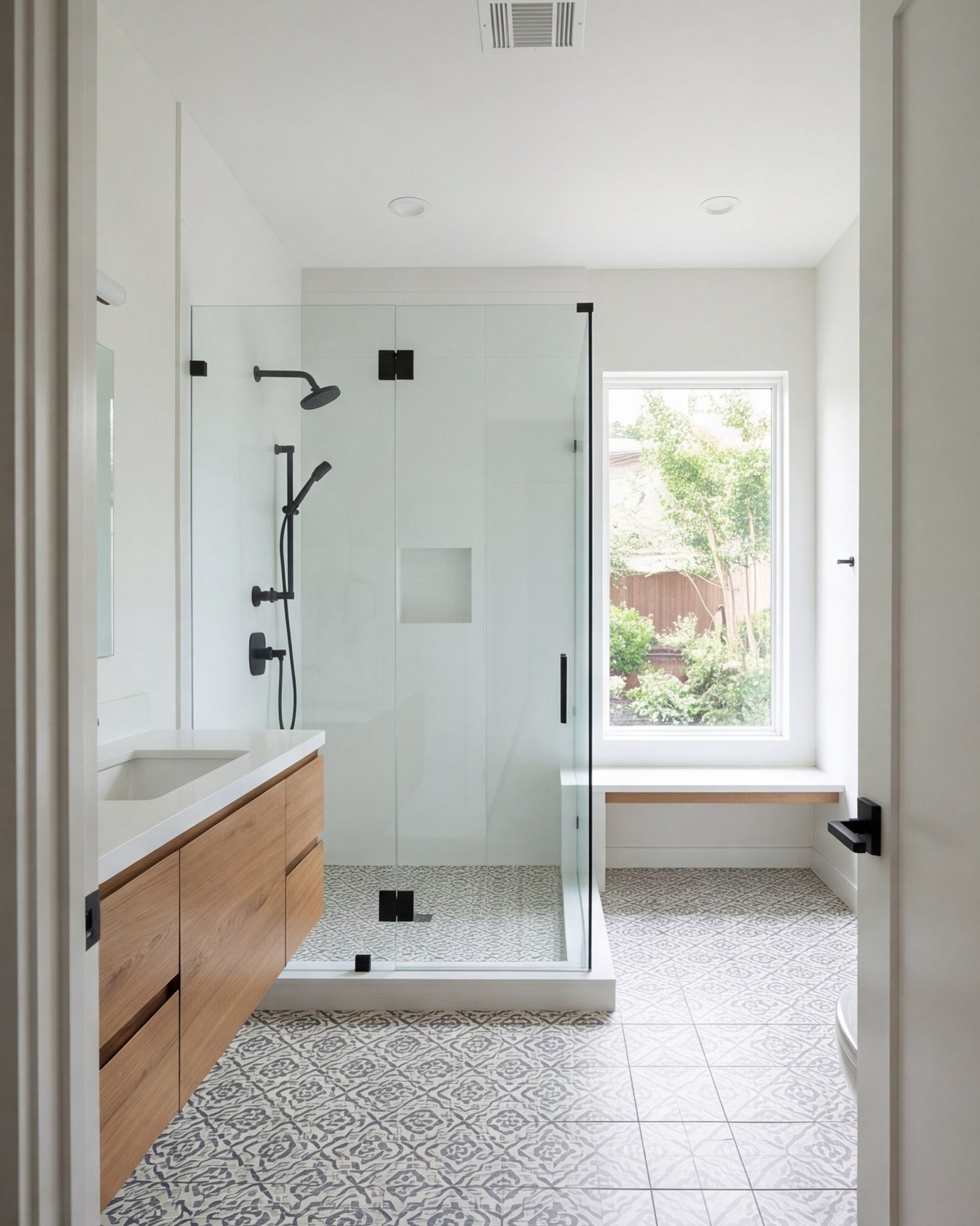 tall view of a finished bathroom from the doorway, glass shower, tile floor, window