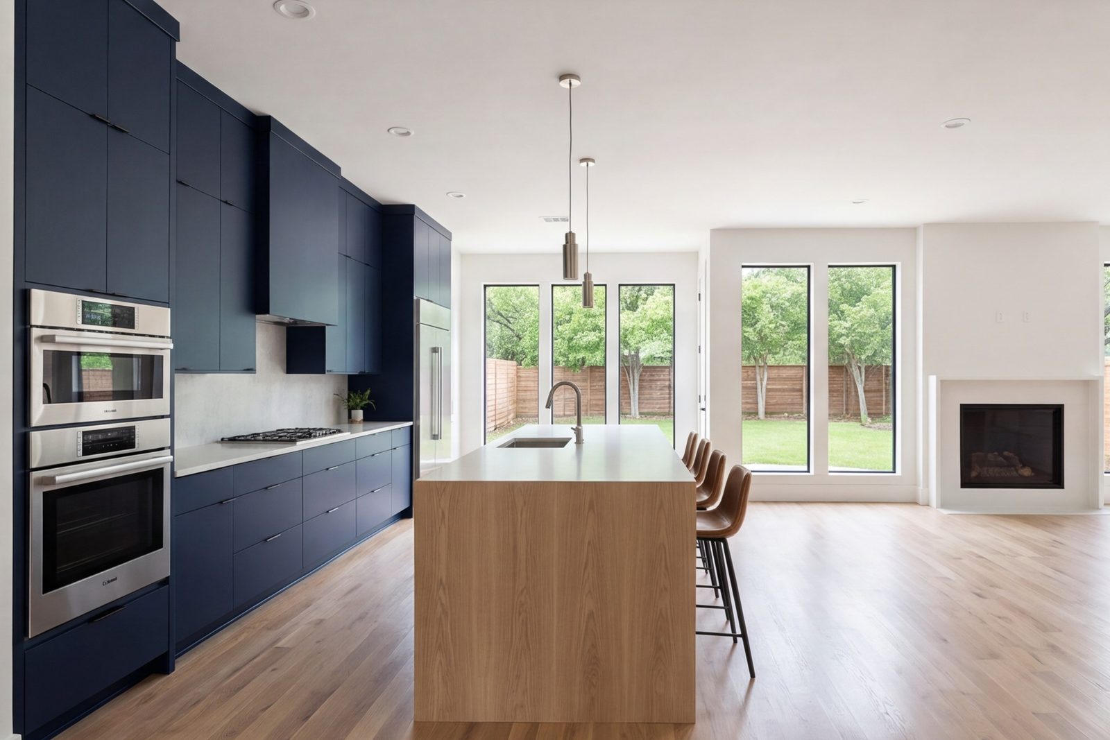 Open kitchen and den with a long cabinet wall and island seating